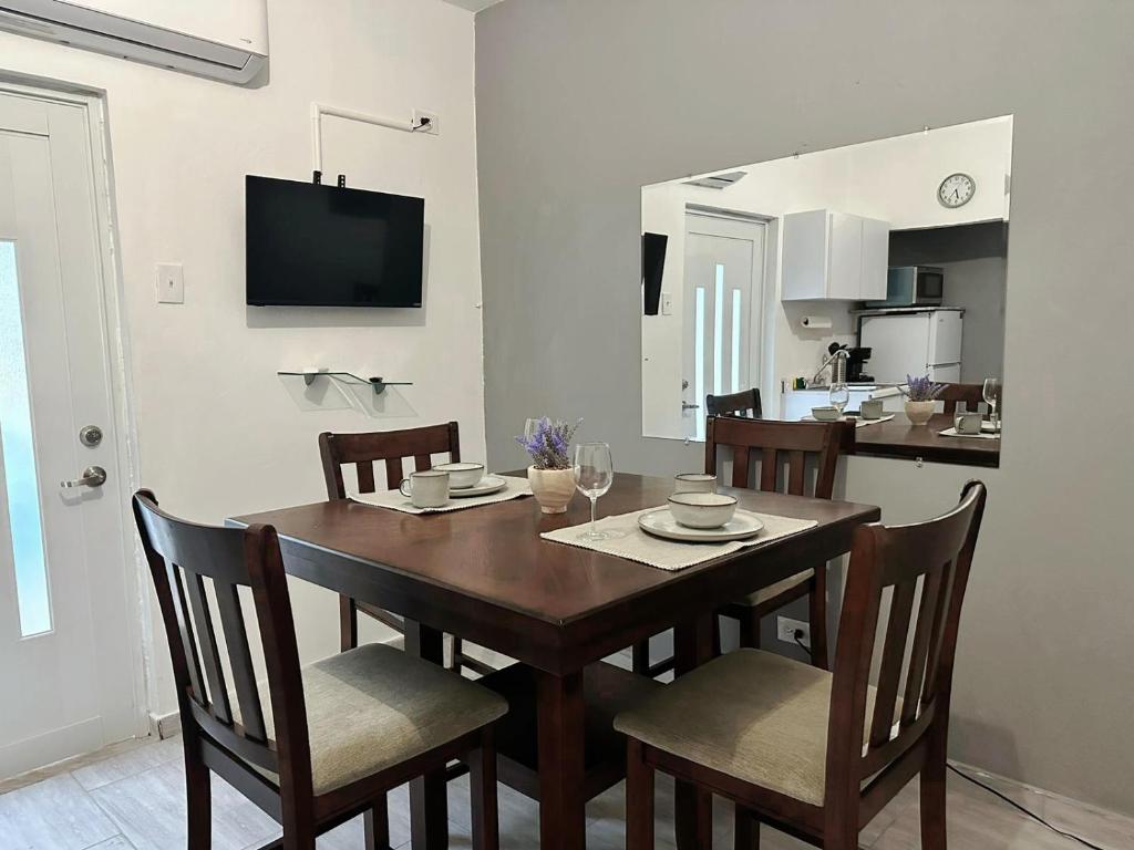 a dining room table with chairs and a kitchen at Urban Lodgings Two @ Roosevelt 457 in San Juan