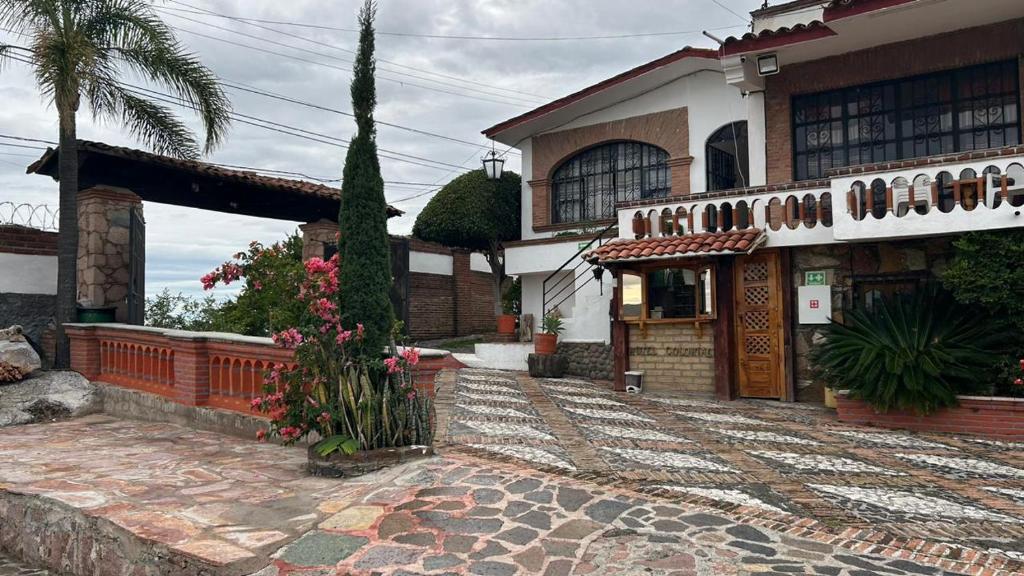 una grande casa con una palma e un edificio di Hotel Colonial Taxco a Taxco de Alarcón