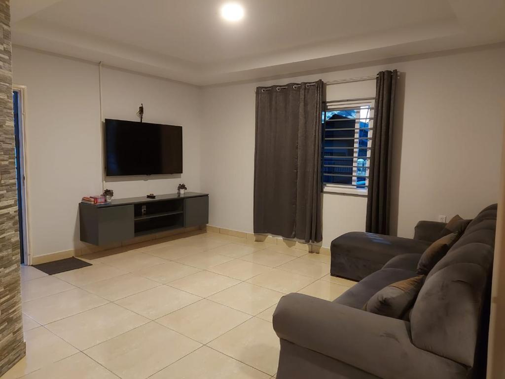 a living room with a couch and a flat screen tv at A&N appartementen in Lelydorp