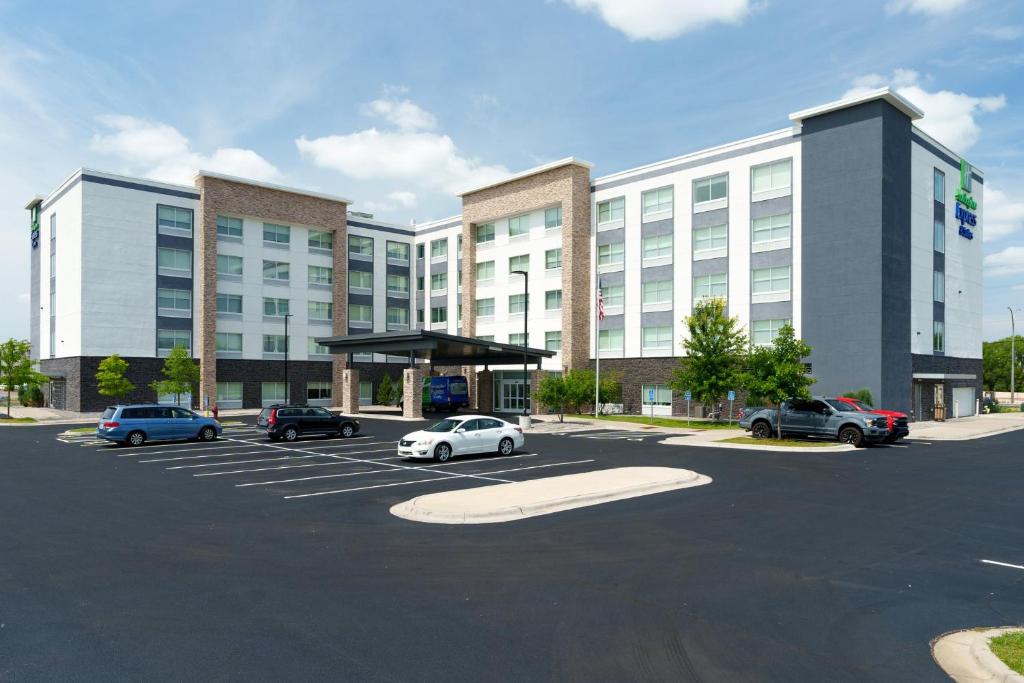 un estacionamiento con autos estacionados frente a un edificio en Holiday Inn Express & Suites - Mall of America - MSP Airport, an IHG Hotel en Bloomington