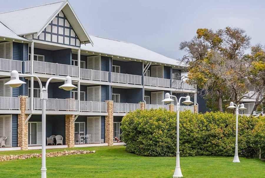 an exterior view of a large apartment building with lights at Caves House Hotel Apartments in Yallingup
