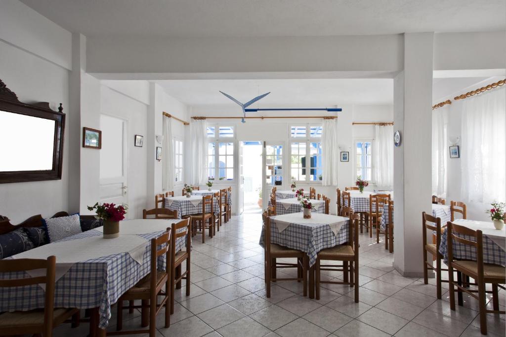 restauracja ze stołami i krzesłami w pokoju w obiekcie Ancient Thera Studios w mieście Perissa