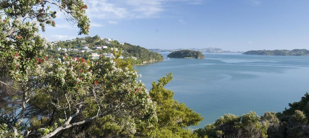 vista su una grande cassa d'acqua con alberi di The Retreat a Paihia