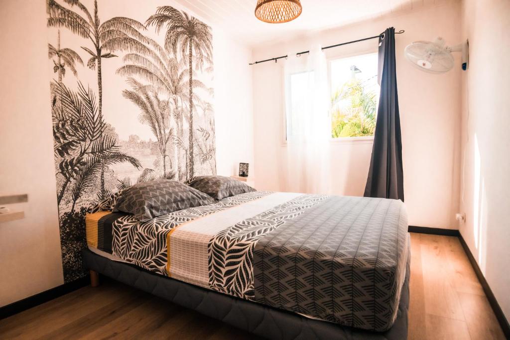 - une chambre avec un lit et du papier peint tropical dans l'établissement Lilie location langevin, à Saint-Joseph