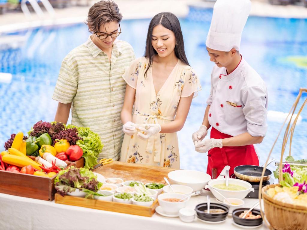 a group of people preparing food next to a pool at DLG Hotel Danang in Da Nang
