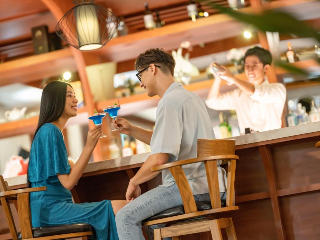 a group of people sitting at a bar at DLG Hotel Danang in Da Nang