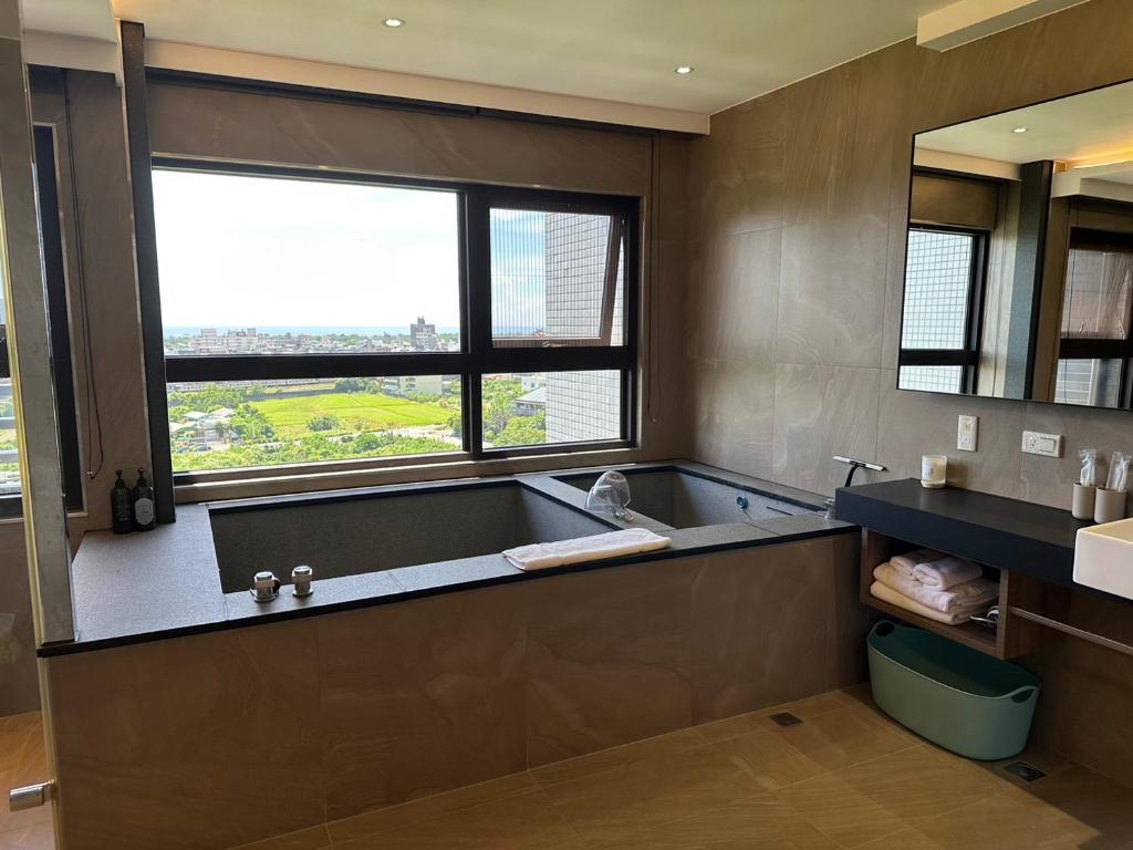 a bathroom with a tub and a large window at 幸福M&M House-龜山日出溫泉景觀宅 in Toucheng