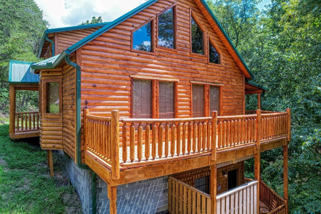 une cabane en rondins entourée d'une terrasse. dans l'établissement Pine Haven Hollow, à Pigeon Forge