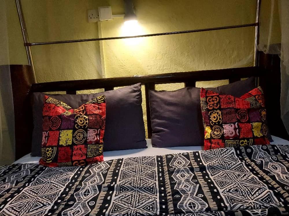 a bed with pillows on it with at Sarah’s place in Mbale