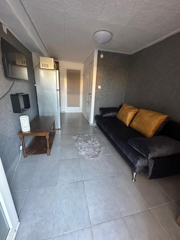 ein Wohnzimmer mit einem schwarzen Sofa und einem Tisch in der Unterkunft În Buna Ziua in Cluj-Napoca
