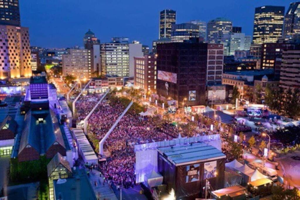 uma grande multidão de pessoas em uma cidade à noite em 2 bedroom Condo in the heart of the city Montreal em Montreal