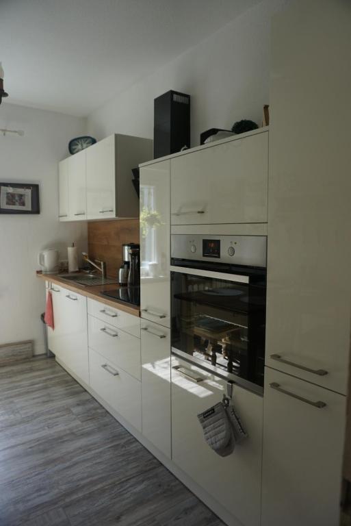 eine Küche mit weißen Schränken und einem Backofen in der Unterkunft Dat Wittsche Hus - Ferienwohnung an der Nordsee in Wilhelmshaven