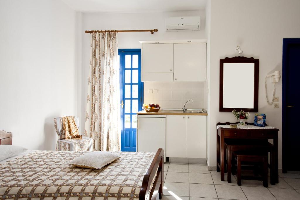 a bedroom with a bed and a table and a kitchen at Ancient Thera Studios in Perissa