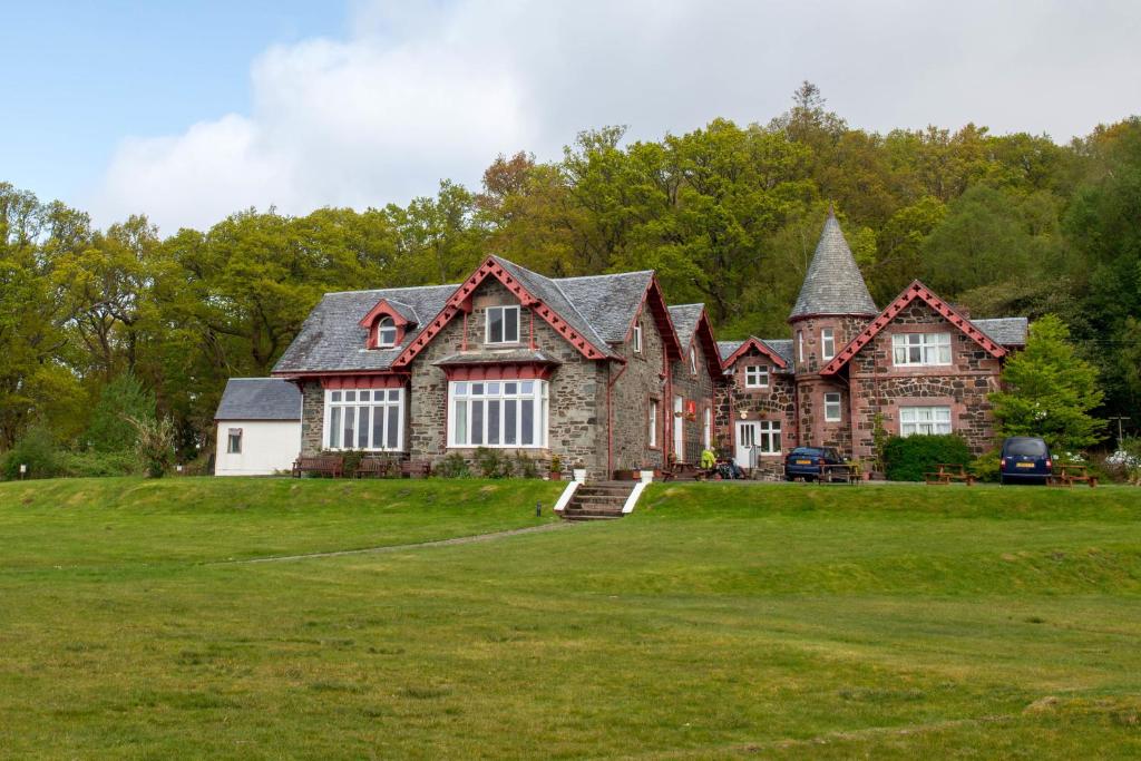 una casa grande en un campo de hierba en Rowardennan Youth Hostel, en Rowardennan