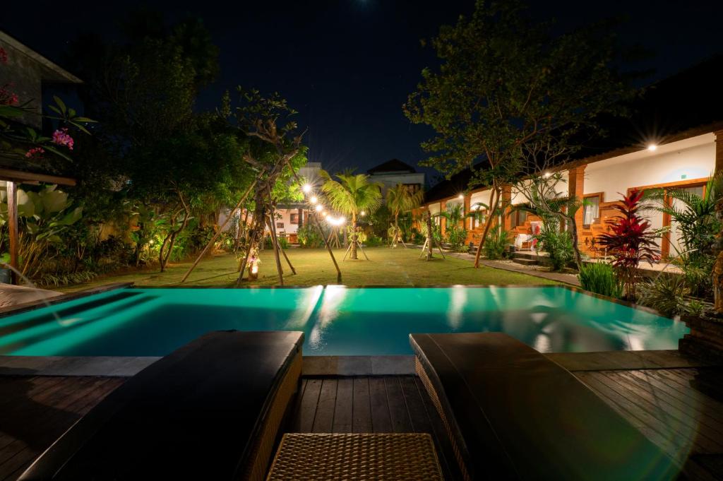 a swimming pool in the middle of a house at night at Asri Guesthouse in Canggu