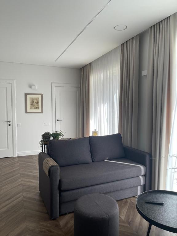 a living room with a blue couch and a table at Obelų Apartamentai in Klaipėda