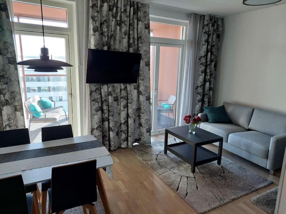 a living room with a couch and a table at Kotimaailma Apartments Vapaudenkatu 47 in Jyväskylä