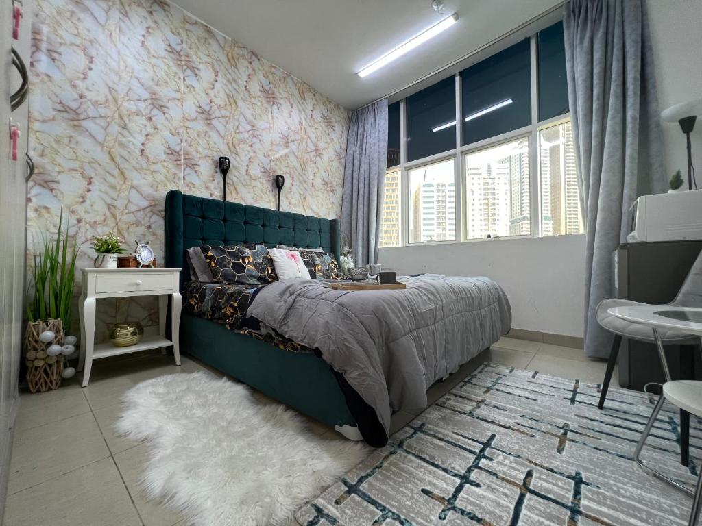 Park view bedroom in family apartment في الشارقة: غرفة نوم بسرير اخضر كبير وبجدار ورد