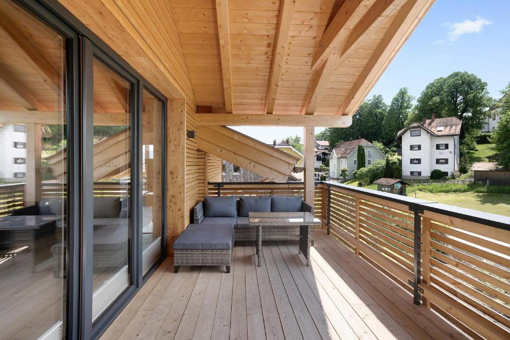 una terraza de madera con sofá en Ferienwohnung Schwaiger Almblick, en Bad Tölz