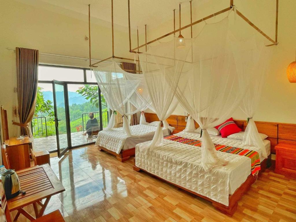 a bedroom with two beds with mosquito nets at Mai Hill Homestay in Ải Hạ