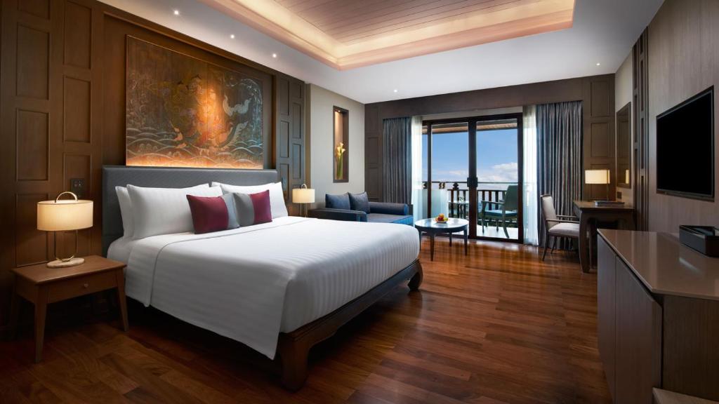 a bedroom with a large bed and a living room at Amari Vogue Krabi in Tab Kaek Beach