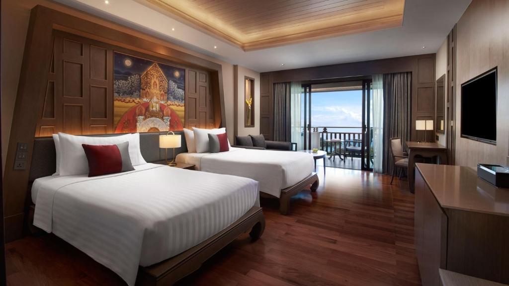 a hotel room with two beds and a balcony at Amari Vogue Krabi in Tab Kaek Beach