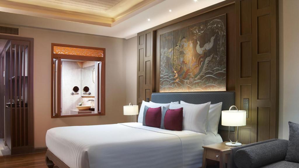 a bedroom with a large white bed and a chair at Amari Vogue Krabi in Tab Kaek Beach