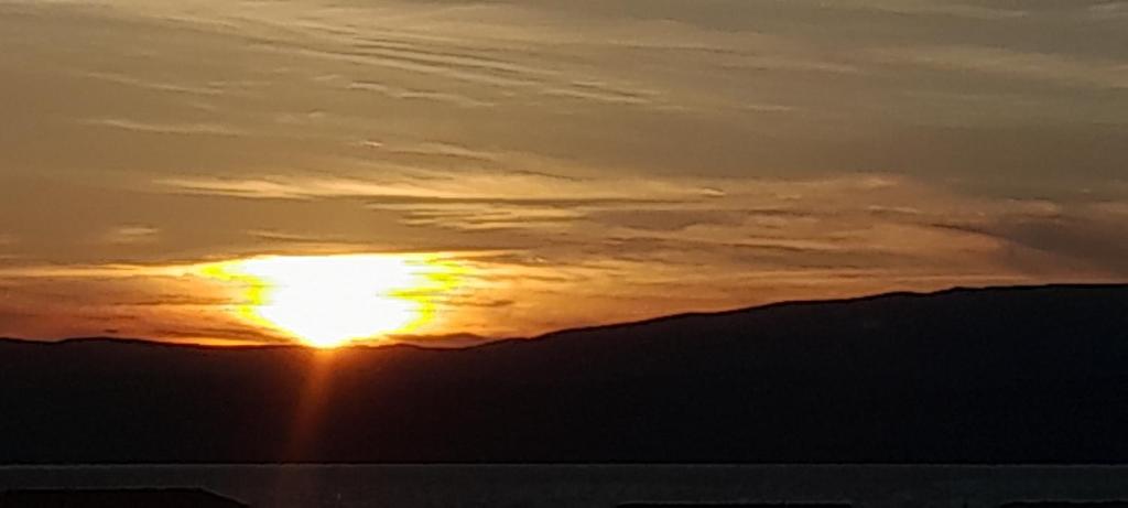 una puesta de sol con el sol en el cielo en CHARMANT DUPLEX 3ÈME ÉTAGE AVEC VUE IMPRENABLE, en Le Barcarès