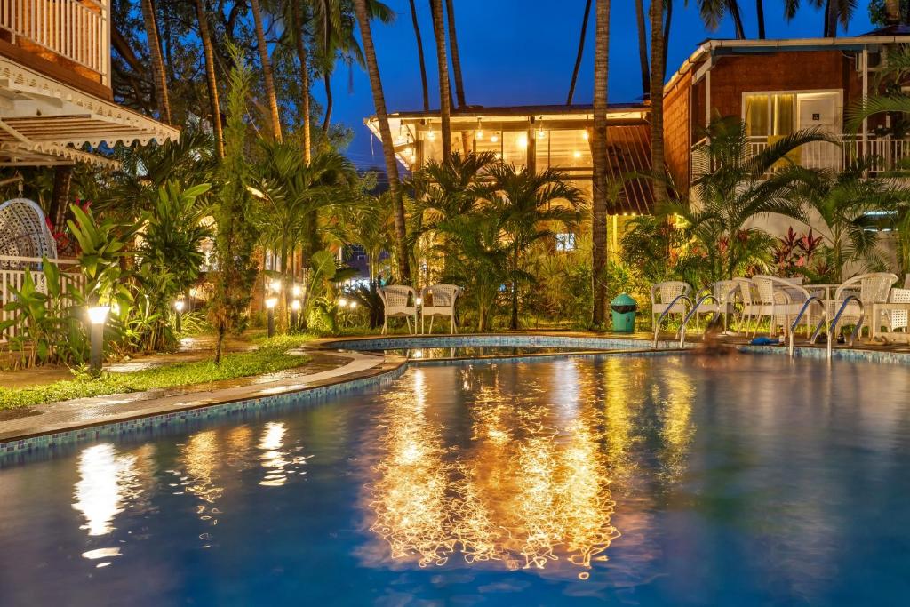 a swimming pool in a resort at night at Skon Morjim Beach Resort by Orion Hotels in Morjim