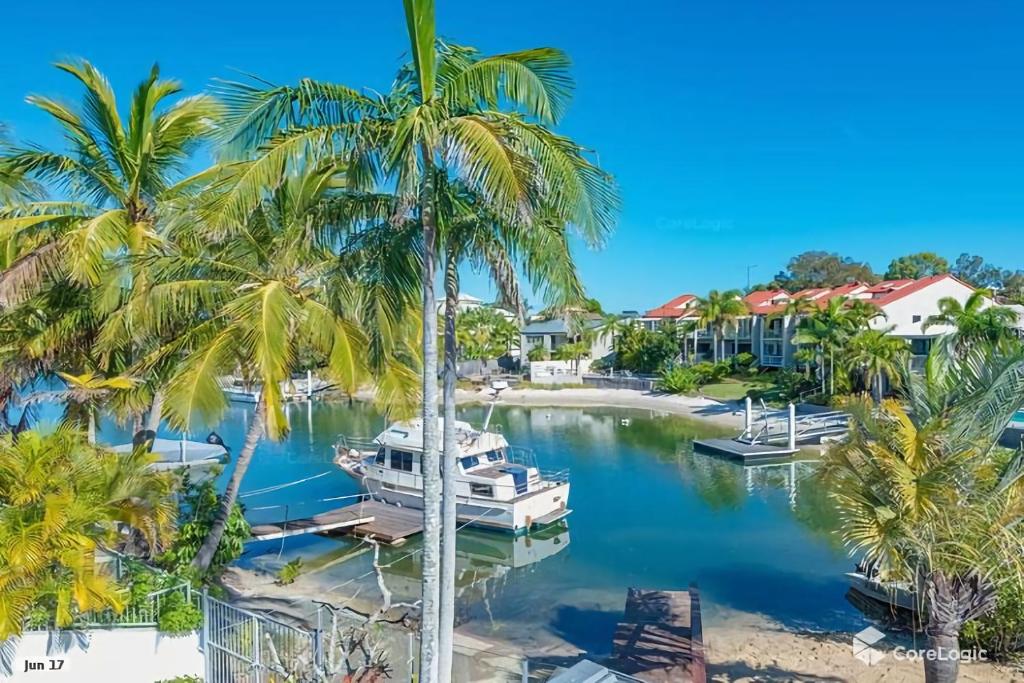a boat docked at a marina with palm trees at 14 Cooran Court in Noosa Heads