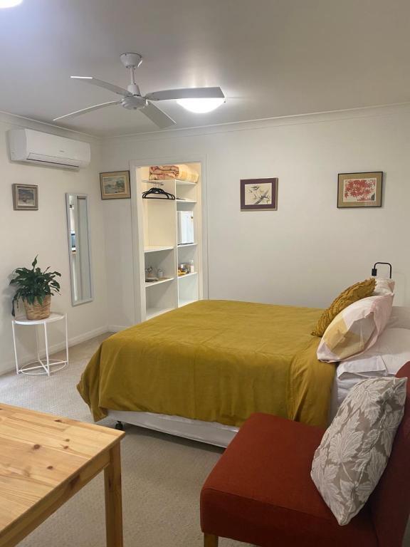 a bedroom with a large bed and a couch at Private Room with Ensuite in Yass