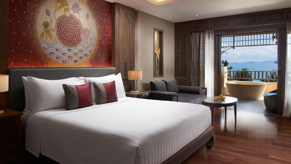 a bedroom with a large bed and a living room at Amari Vogue Krabi in Tab Kaek Beach