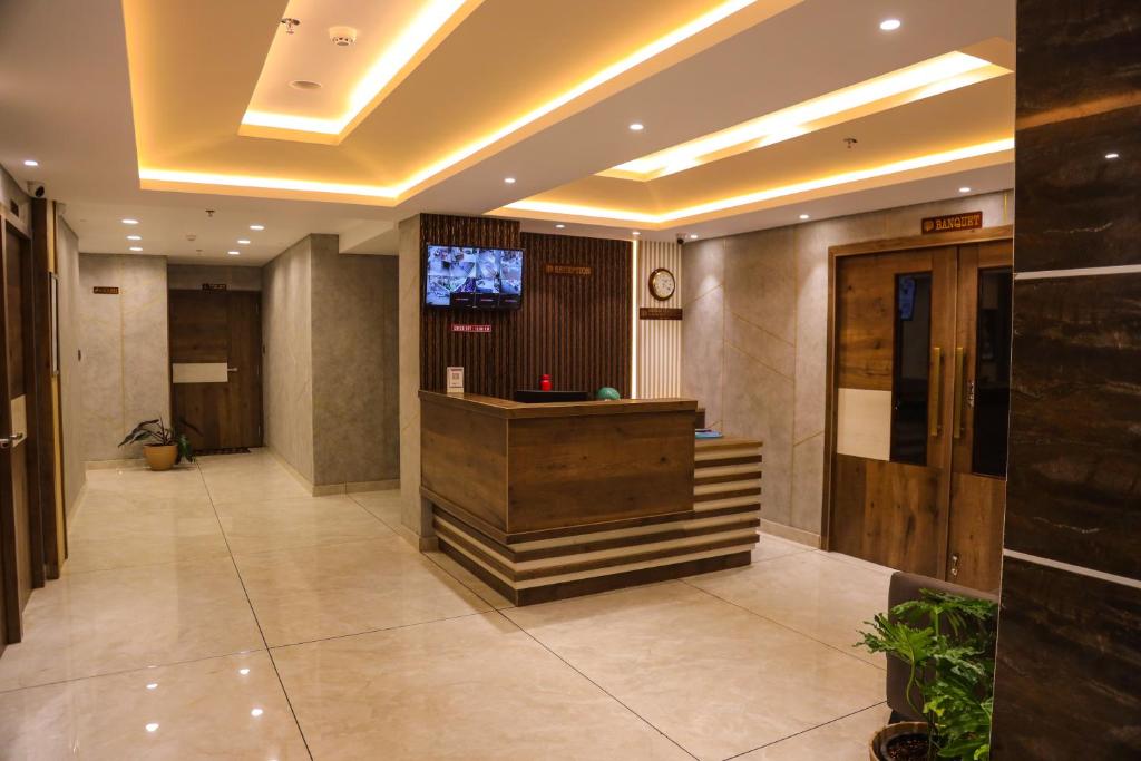 Mezkar Residency في Alwaye: لوبي الفندق مع مكتب استقبال وتلفزيون
