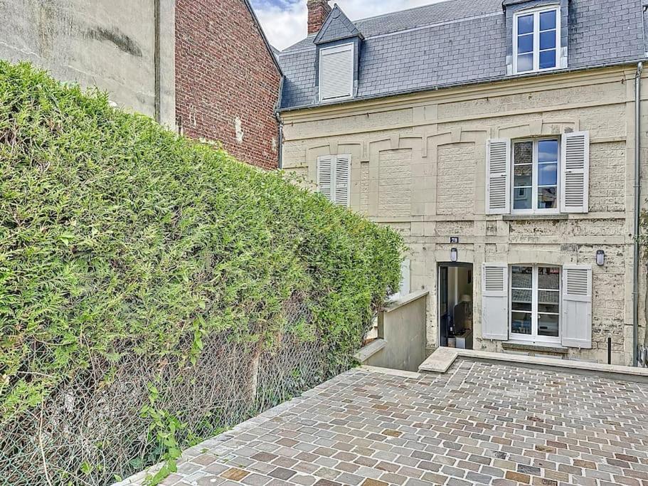 an ivy covered wall in front of a building at La Deauvilloise YourHostHelper in Deauville