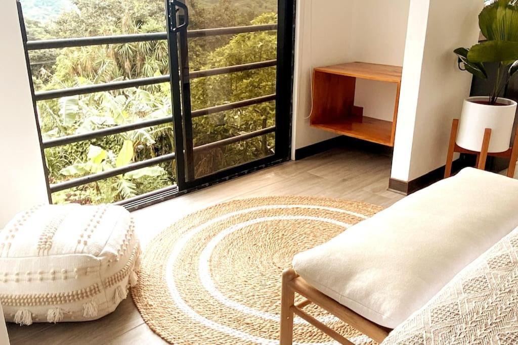 蒙特韋爾德哥斯達黎加的住宿－Calma, Monteverde - Expect Serenity Here，客房设有椅子和大窗户。