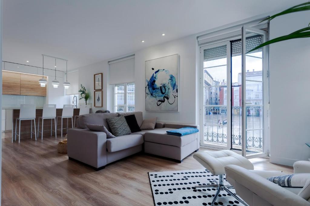 uma sala de estar com um sofá, uma mesa e uma cozinha em Cinco balcones a la Catedral by Unique Rooms em Burgos