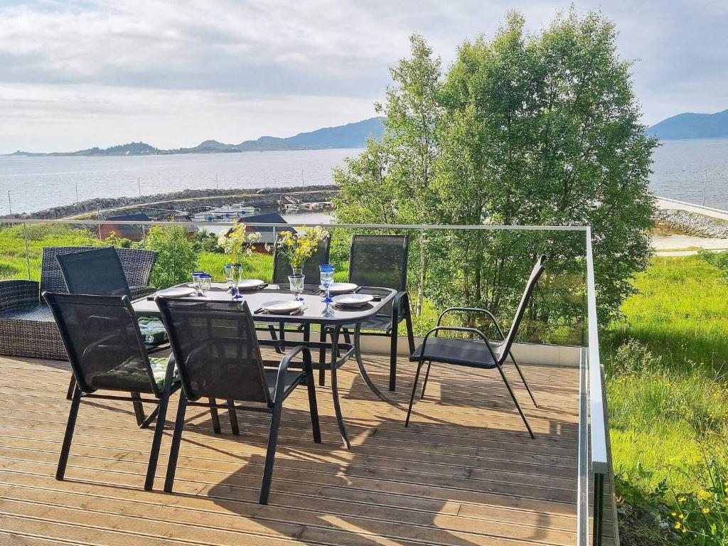a table and chairs on a deck with a view of the water at 8 person holiday home in Åram in Sandvik