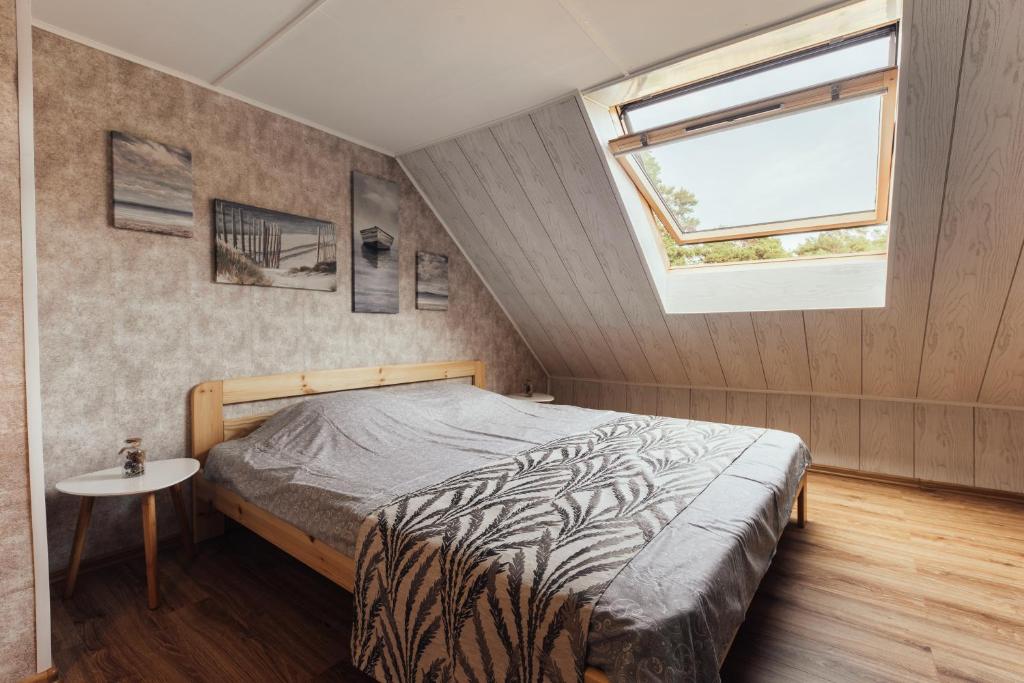 a bedroom with a bed and a window at Beach Home for Nature Lovers in Bernāti