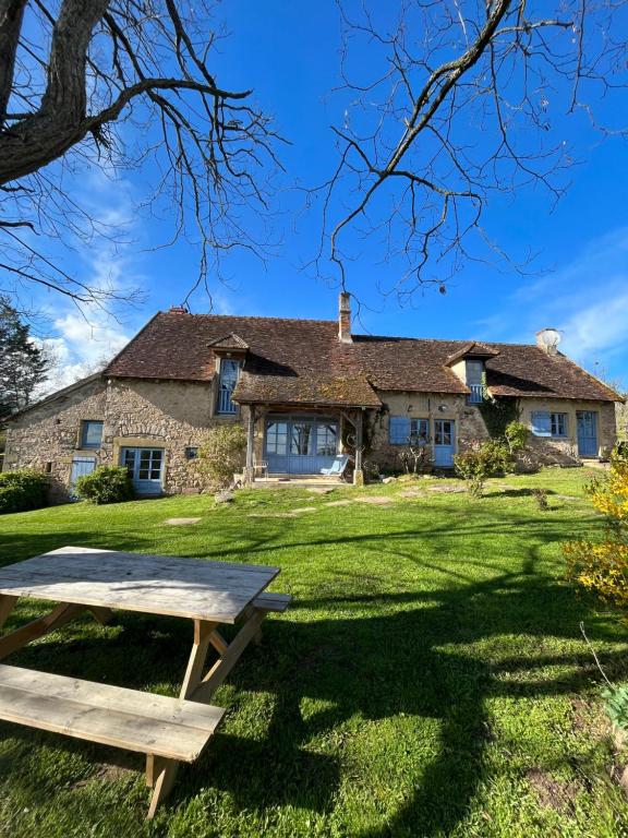 a picnic table in front of a stone house at Gîte de la Doit, en pleine campagne, pour 14 pers in Saint-Marcelin-de-Cray