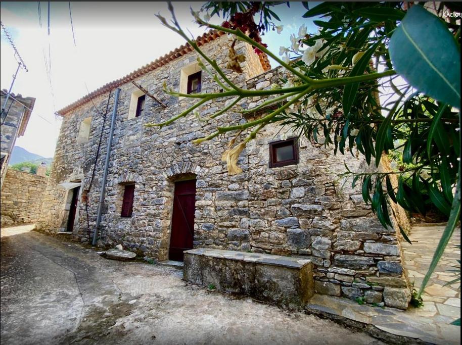 POLLY FOURNAROU tower-house في Miléa: مبنى حجري قديم بباب احمر
