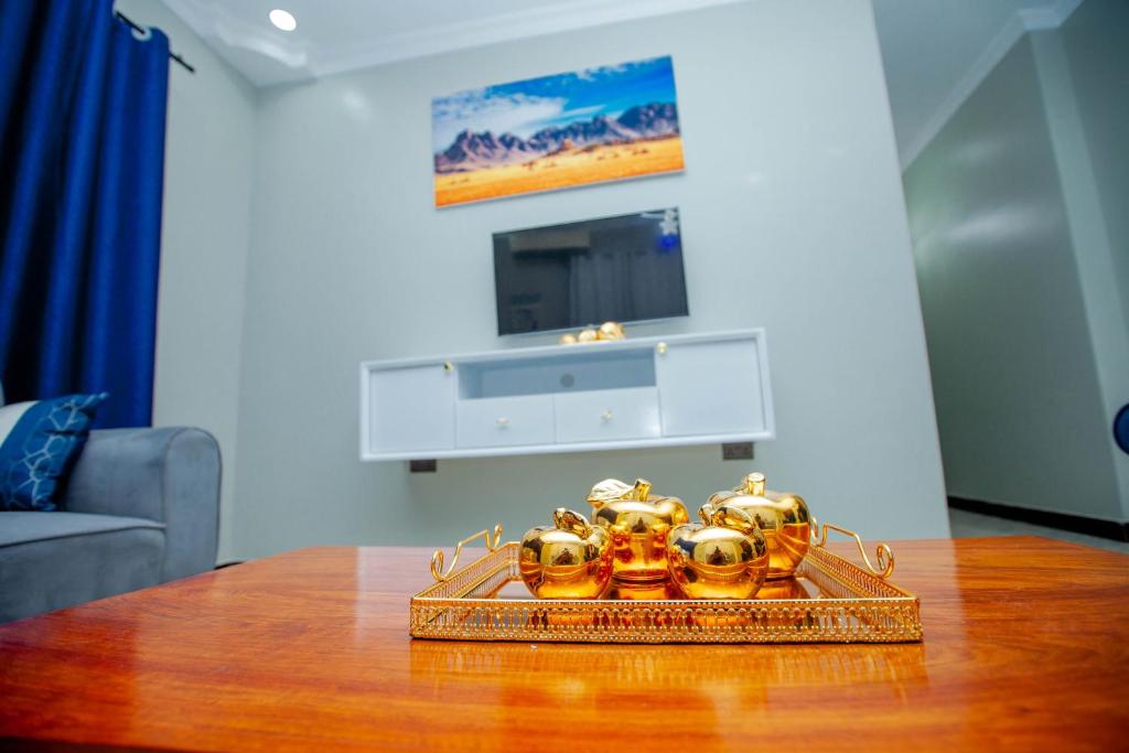 un tavolo con un vassoio di oggetti d'oro sopra di Niwa Apartments a Dar es Salaam