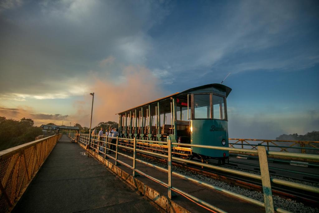 a train on a bridge with people on it at Room in Villa - Zambezi Family Lodge - Buffalo Room in Victoria Falls