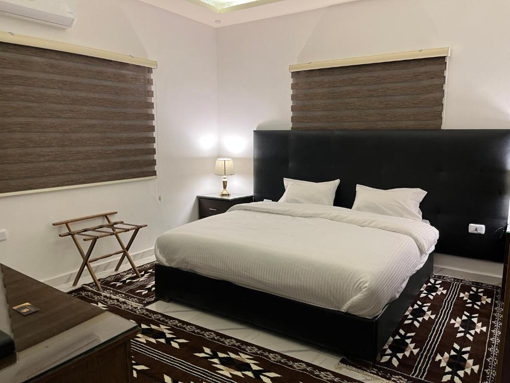 a bedroom with a large bed with a black headboard at Mansi Residence in Wadi Musa