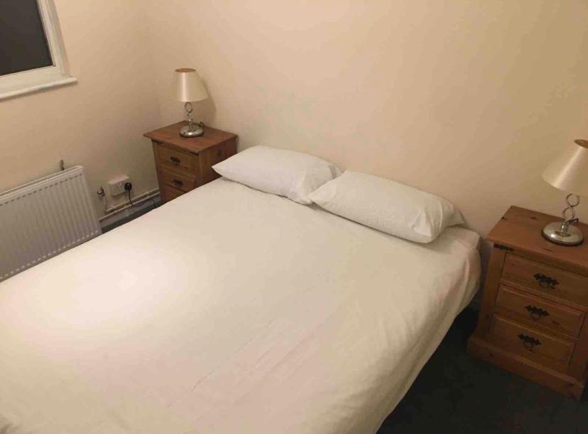 a bedroom with a white bed and two night stands at Eastbourne Double room free WiFi in Polegate