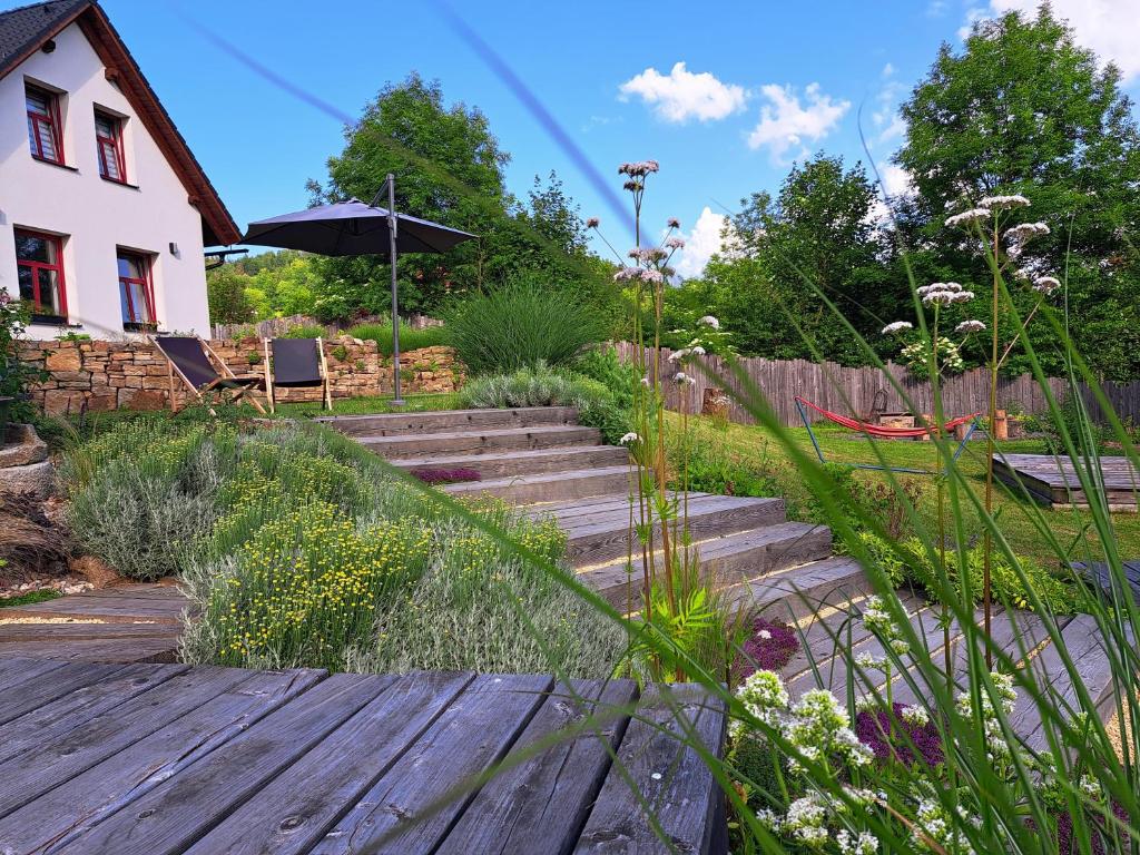 einen Garten mit Treppe und ein Haus mit Sonnenschirm in der Unterkunft Ateliér 673 in Dolní Bečva