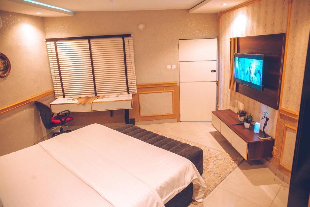 GwarinpaにあるSomewhere Apartmentのベッドとテレビが備わるホテルルームです。