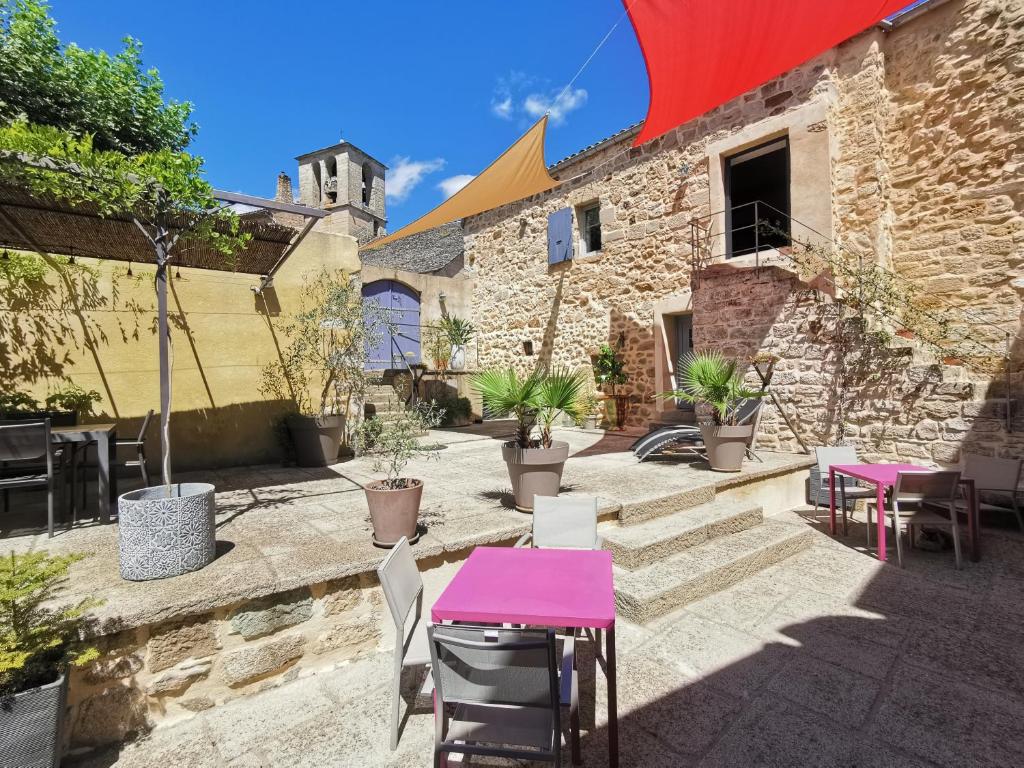 une terrasse avec une table et des chaises roses dans l'établissement Le Mas des Loges - Les Vans / Chambonas, à Chambonas