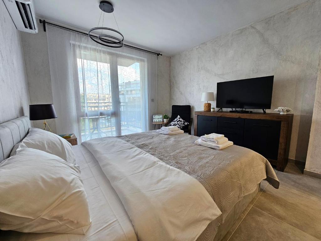 um quarto com uma cama grande e uma televisão de ecrã plano em Rea Home Apartment em Sófia