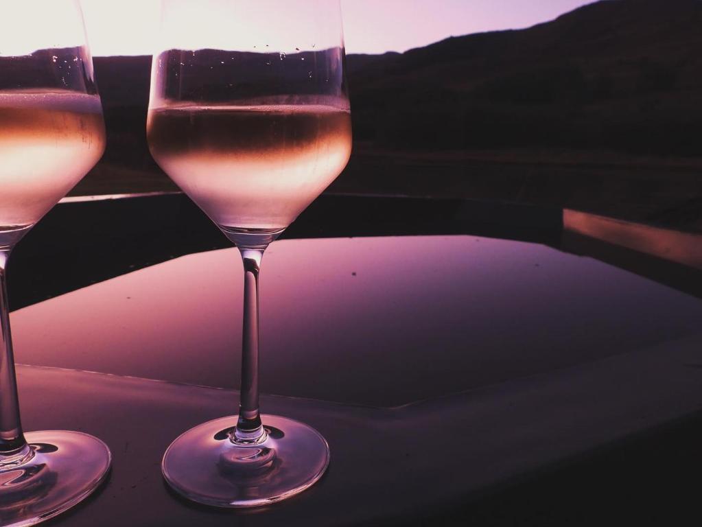 two glasses of wine sitting on a table at African Leaves Trout Lodge in Dullstroom
