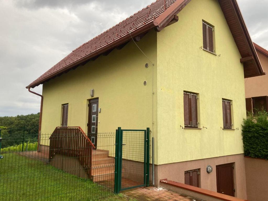una casa amarilla con una puerta delante de ella en Prekmurski raj, en Dobrovnik